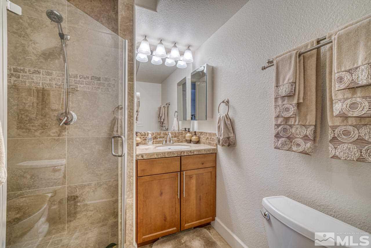 3677 Warren Way, Unit A Reno, NV 89509 - Photo 6 of 22 a bathroom with a granite countertop sink a toilet and a shower