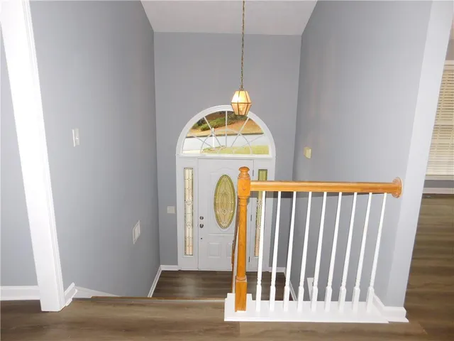 a view of a hallway with wooden floor and a window