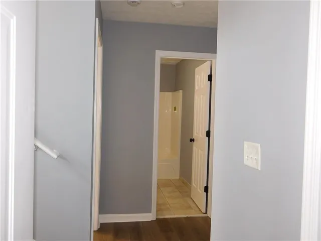 a view of a hallway with windows and bathroom view