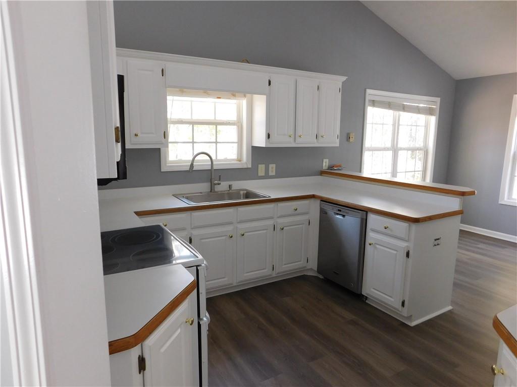 2614 Carolina Court Bethlehem, GA 30620 - Photo 3 of 42 a kitchen with a sink dishwasher a stove and white cabinets with wooden floor