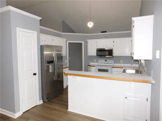 a kitchen with stainless steel appliances a refrigerator a sink a stove a microwave and cabinets