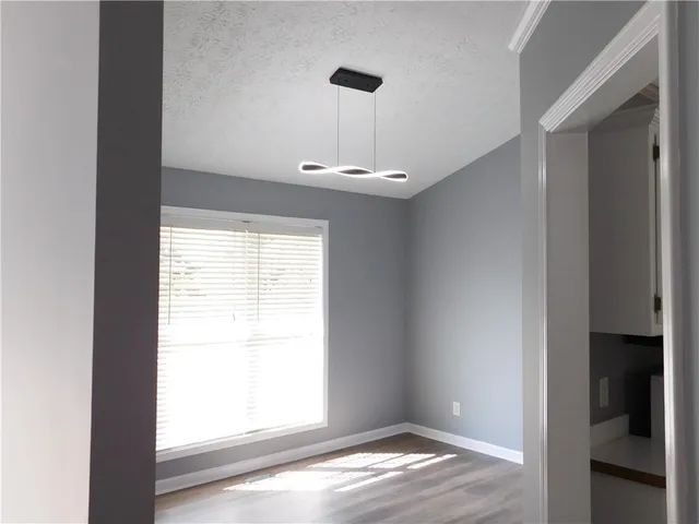 a view of empty room with window and wooden floor