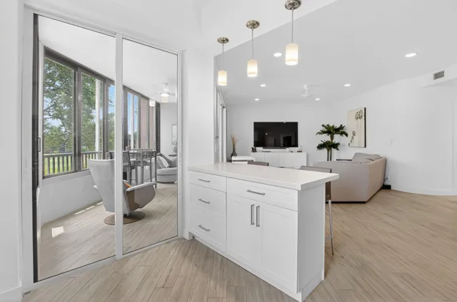 a large white kitchen with a large window