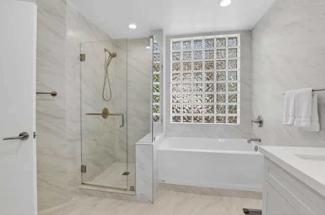 a white bath tub sitting next to a shower