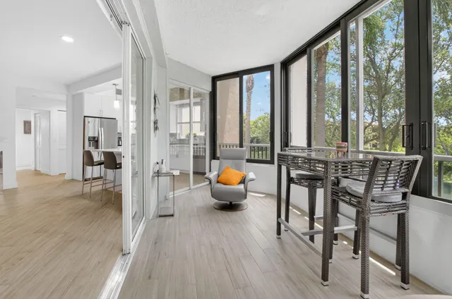 a very nice looking living room with a large window and white wooden cabinets
