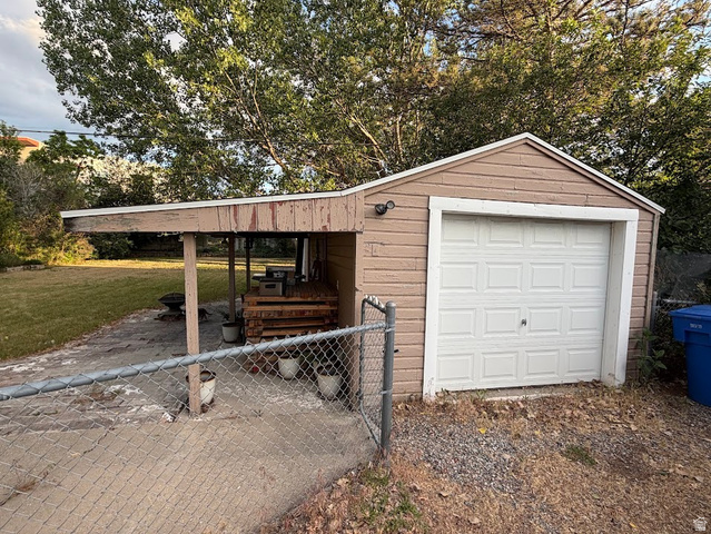 737 Wasatch Street Midvale, UT 84047 - Photo 2 of 29 Detached garage with a white panel door and an attached covered carport