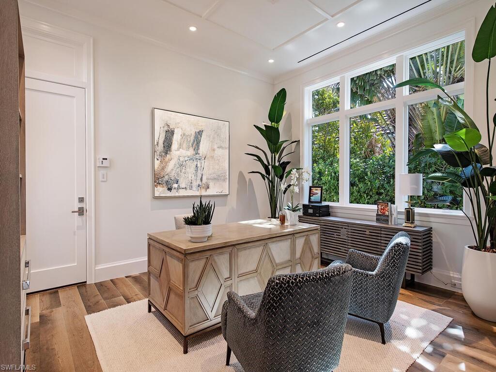 3320 Rum Row Naples, FL 34102 - Photo 18 of 39 a dining room with furniture a large window and potted plants