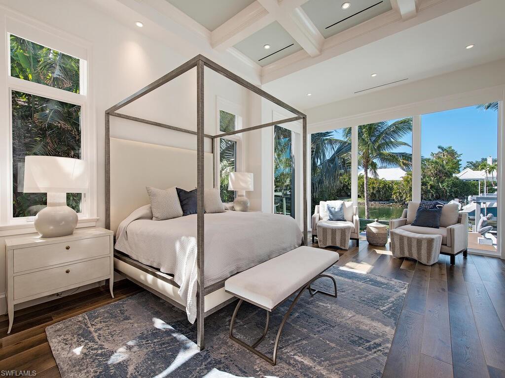 3320 Rum Row Naples, FL 34102 - Photo 23 of 39 a bedroom with a bed and wooden floor