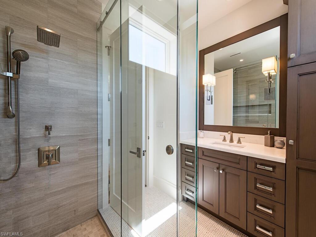 3320 Rum Row Naples, FL 34102 - Photo 32 of 39 a bathroom with a granite countertop sink mirror and shower