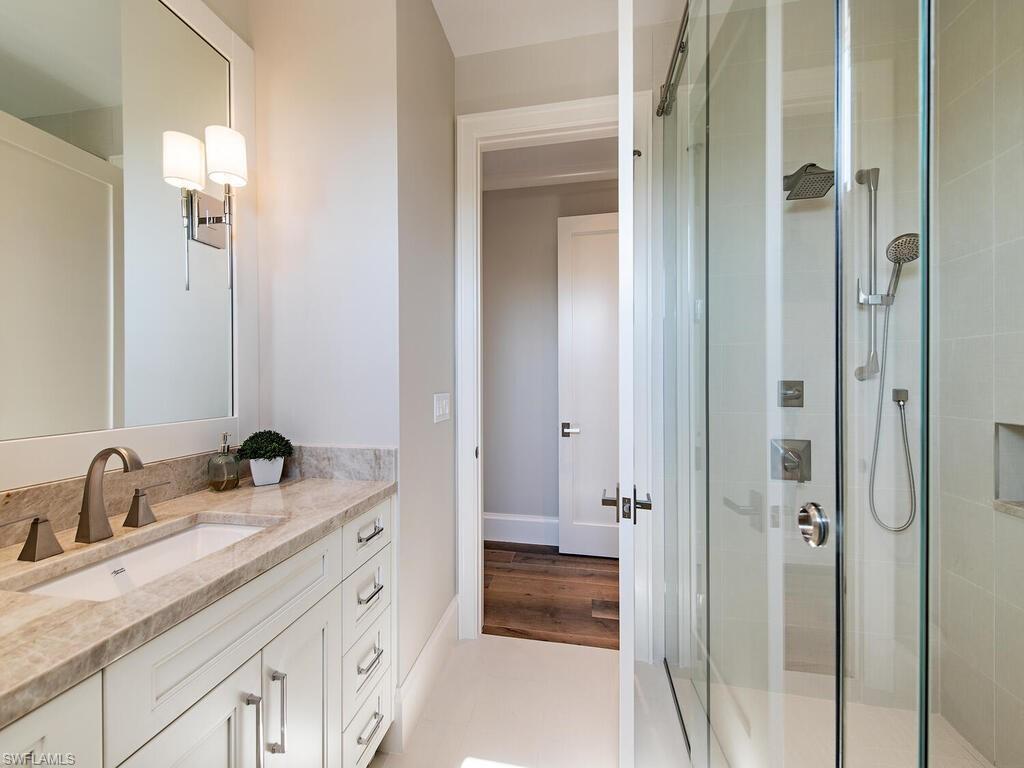 3320 Rum Row Naples, FL 34102 - Photo 34 of 39 a bathroom with double vanity sinks and a mirror