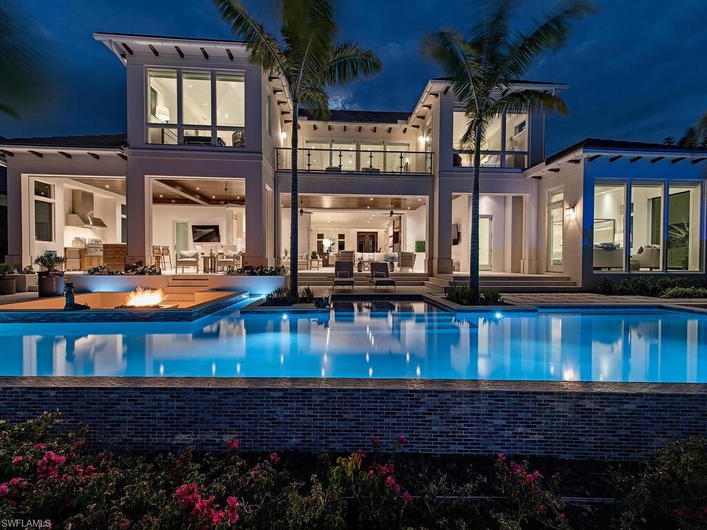 3320 Rum Row Naples, FL 34102 - Photo 4 of 39 a front view of a house with a yard table and chairs
