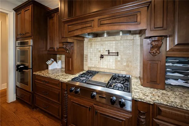a kitchen with granite countertop a stove and a refrigerator