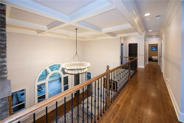 a view of a hallway with wooden floor and staircase