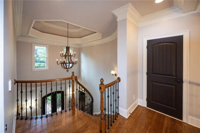 a view of a hallway with wooden floor and staircase