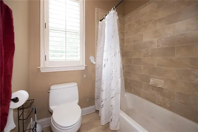 a white toilet sitting next to a bath tub