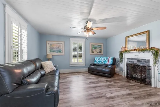 a kitchen with stainless steel appliances kitchen island granite countertop a stove a refrigerator a sink a dining table and chairs with wooden floor