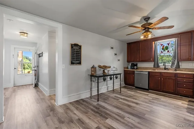 a kitchen with stainless steel appliances granite countertop a stove top oven a sink dishwasher and cabinets with wooden floor