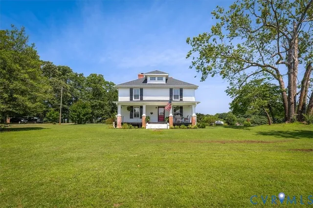a view of a house with a big yard and large trees