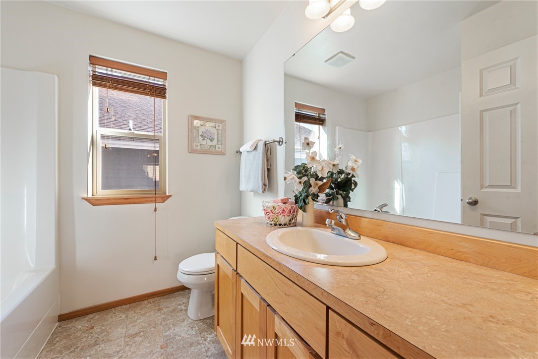 21215 40th Drive Southeast Bothell, WA 98021 - Photo 22 of 25 a bathroom with a granite countertop sink a toilet a mirror and shower
