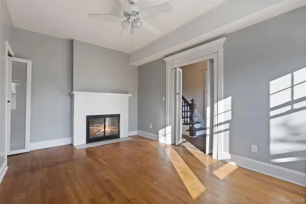 a view of a livingroom with a fireplace window and wooden floor