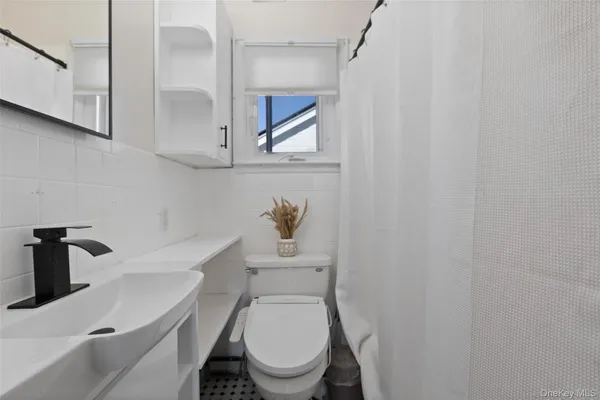 a white toilet sitting next to a sink