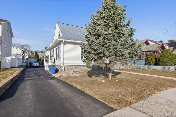 a view of a house with cars park next to a road