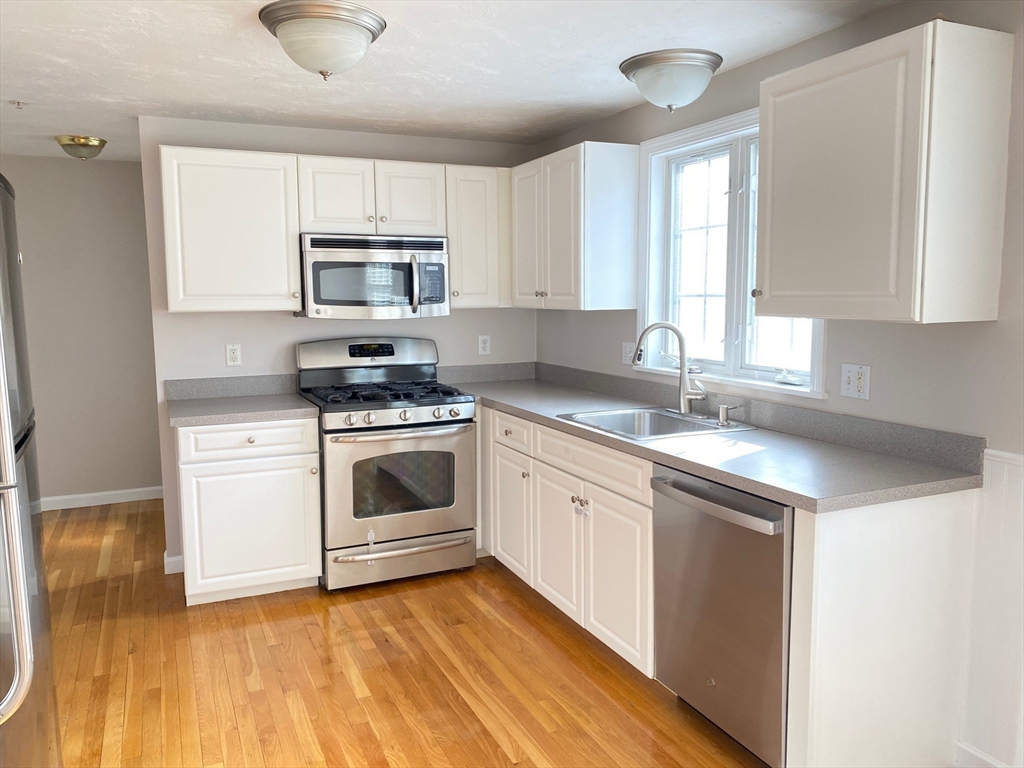 985 Trapelo Road, Unit 6 Waltham, MA 02452 - Photo 3 of 14 a kitchen with granite countertop a sink cabinets and stainless steel appliances