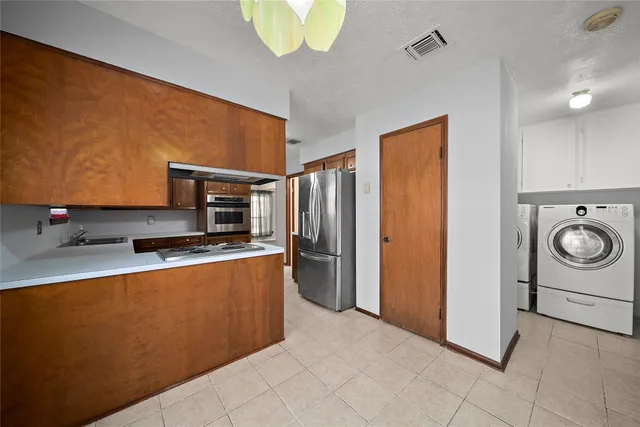 a kitchen with stainless steel appliances granite countertop a refrigerator and a stove top oven