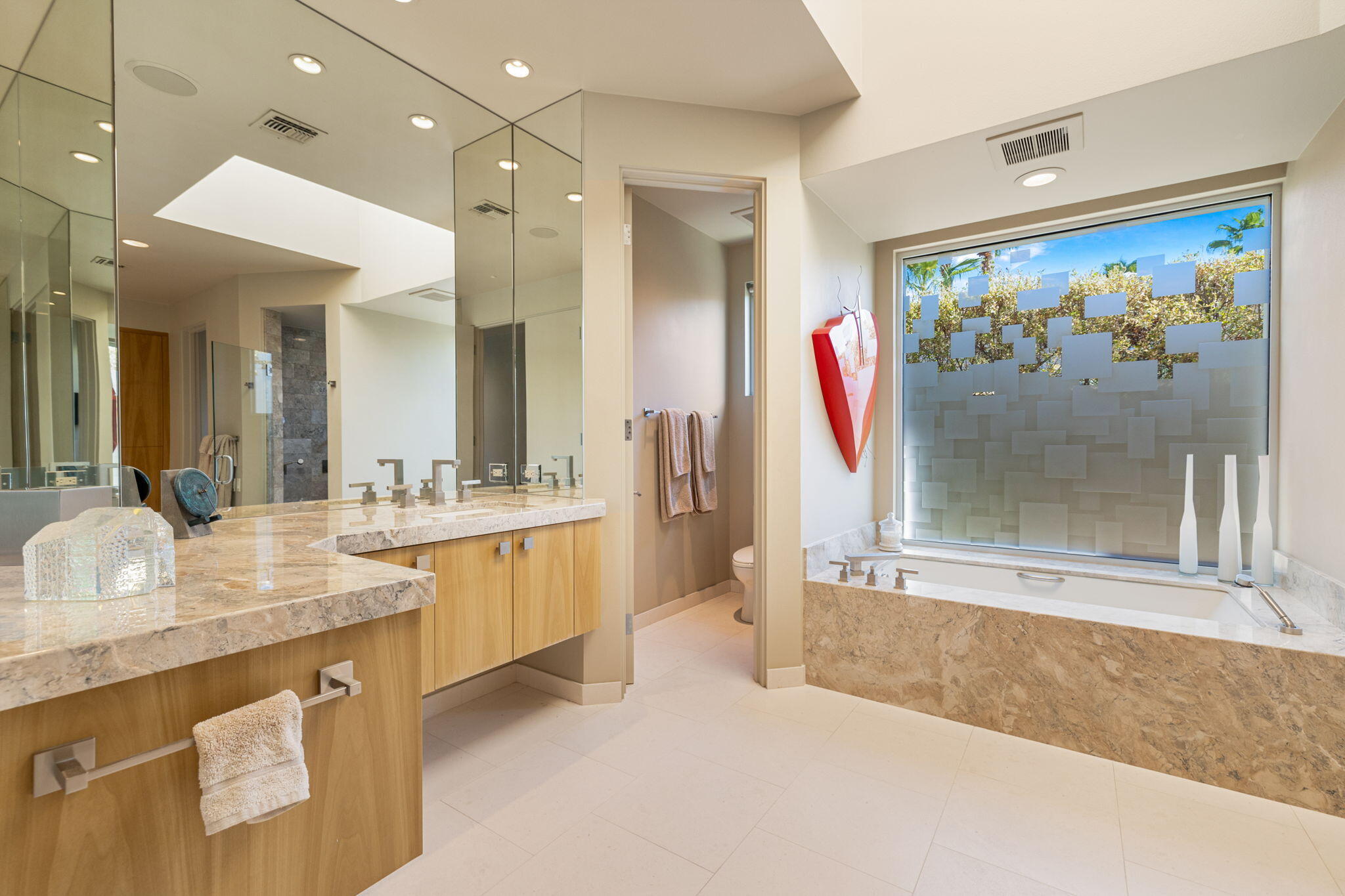 28 Sun Ridge Circle Rancho Mirage, CA 92270 - Photo 31 of 59 a spacious bathroom with a granite countertop sink mirror and painting on the wall