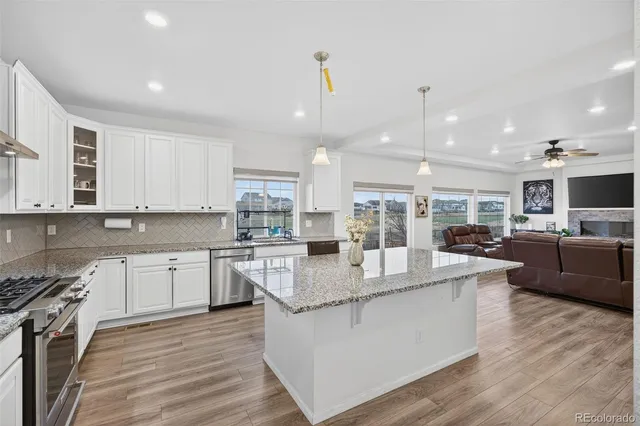 a large kitchen with stainless steel appliances granite countertop a lot of counter top stove and cabinets