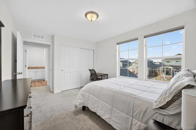 a bedroom with a bed and a large window