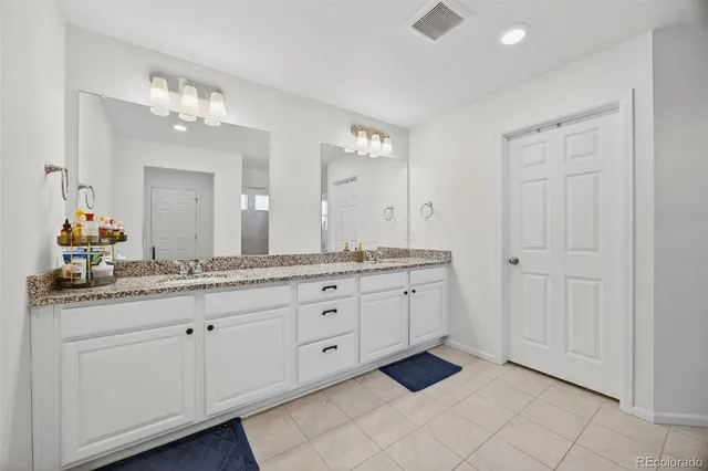 a spacious bathroom with a granite countertop double vanity sink mirror and