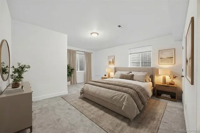 a spacious bedroom with a bed and a potted plant