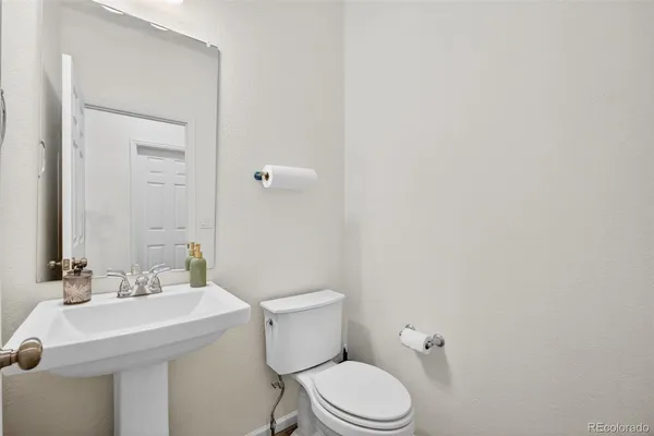 a bathroom with a sink a toilet and a mirror
