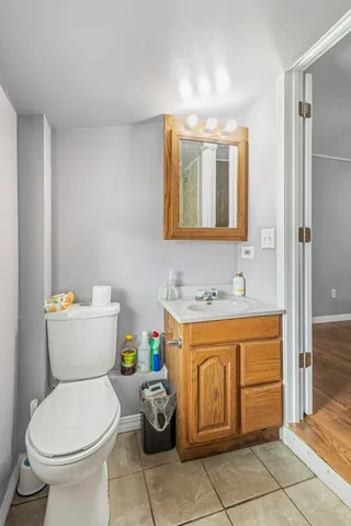 a bathroom with a granite countertop toilet sink and mirror