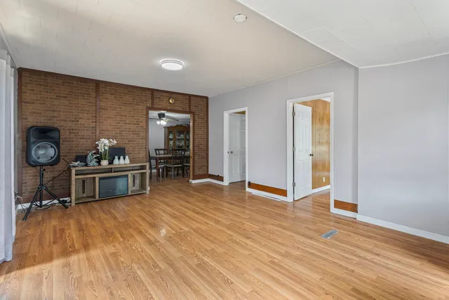 a living room with stainless steel appliances furniture a fireplace and wooden floor