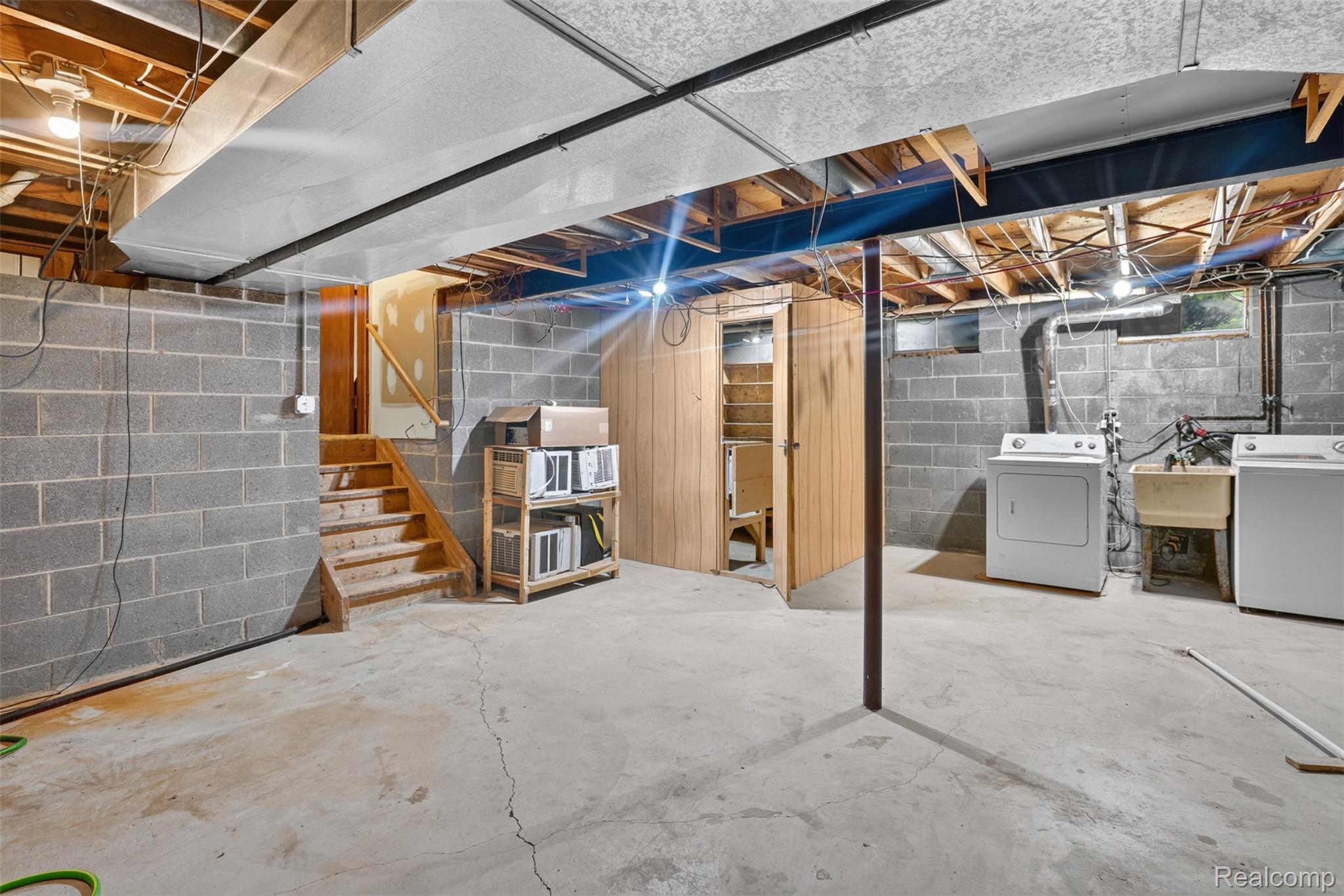 16955 English Road Manchester, MI 48158 - Photo 24 of 37 Unfinished basement featuring concrete block walls, exposed ceiling joists, and a concrete floor