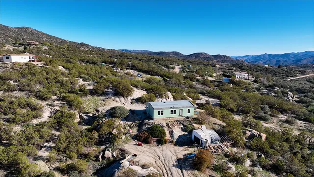 an aerial view of a house with a mountain