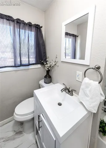 a bathroom with a sink a toilet and mirror