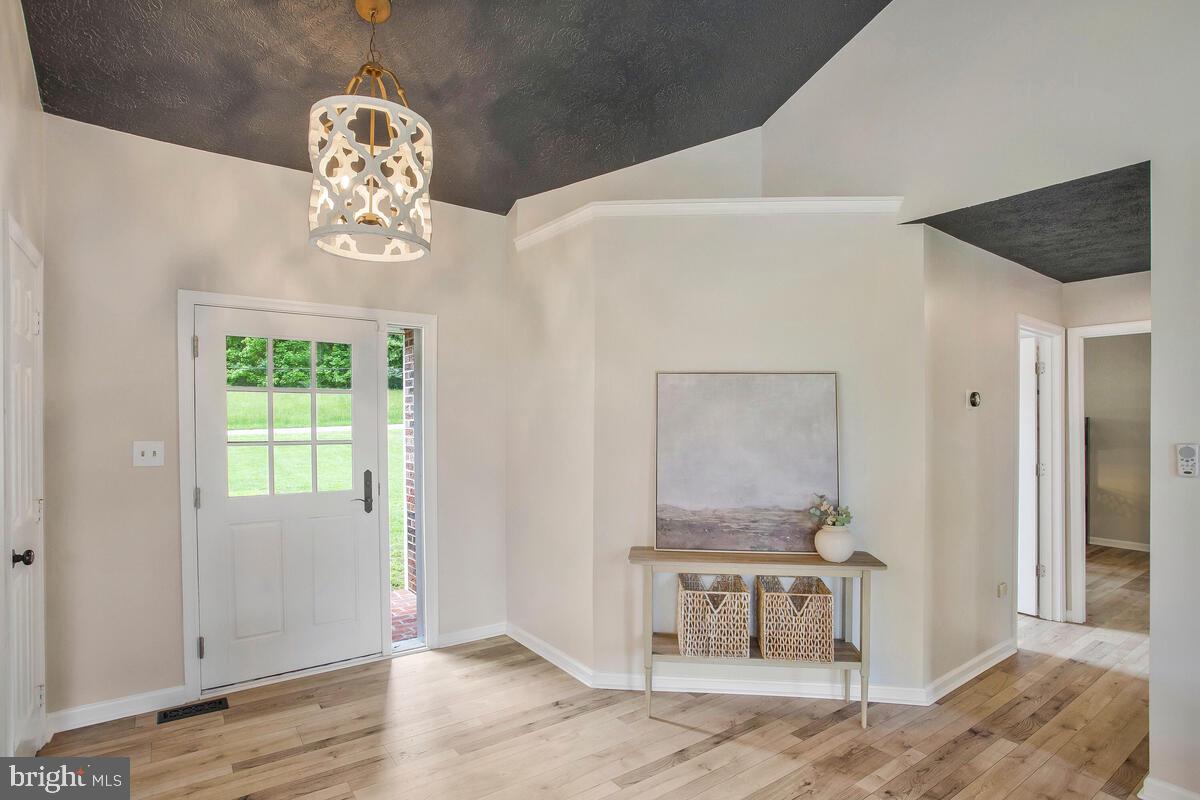 175-m F M F Bowen Road Huntingtown, MD 20639 - Photo 5 of 47 a view of a hallway with wooden floor and chandelier