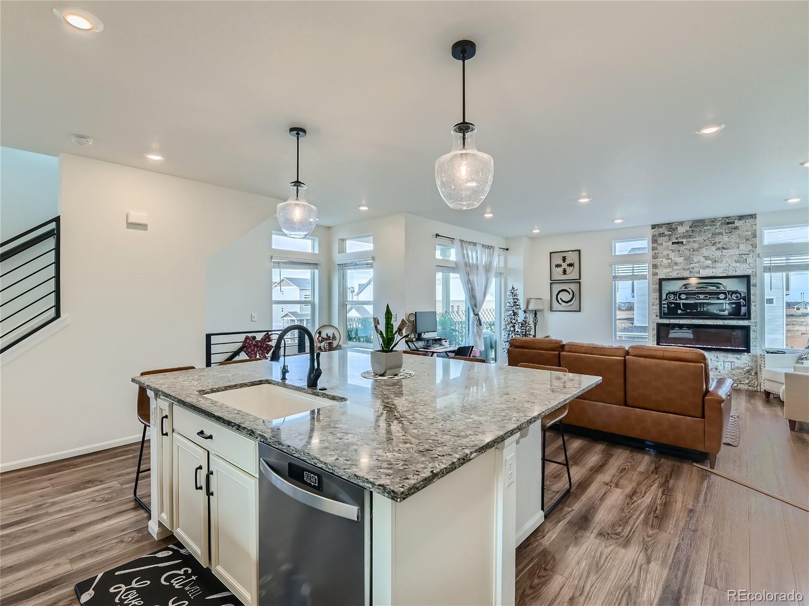 a kitchen with stainless steel appliances granite countertop stove top oven and couches