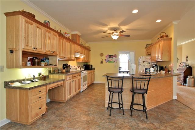 1214 Ben Collier Road Charlotte, TN 37036 - Photo 4 of 20 a kitchen with a sink a cabinets and chairs