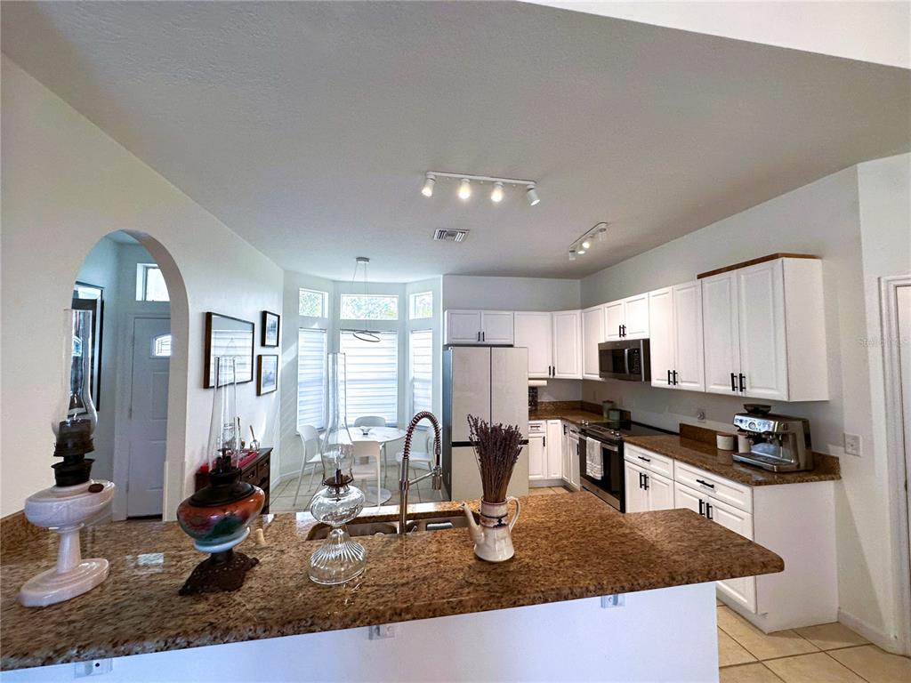 700 Castillo Place St. Cloud, FL 34769 - Photo 11 of 43 a kitchen with sink a stove and cabinets