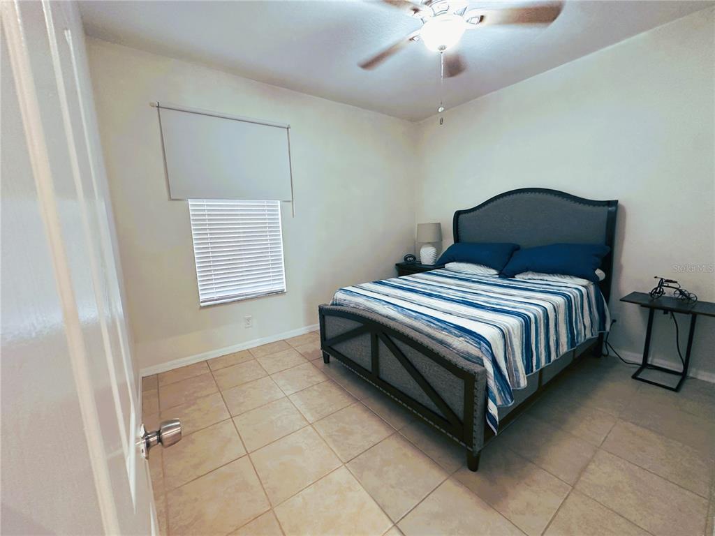 700 Castillo Place St. Cloud, FL 34769 - Photo 25 of 43 a bedroom with a bed and a chandelier