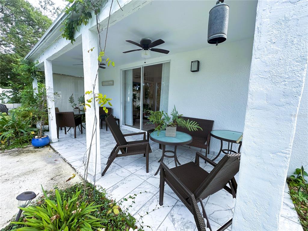 700 Castillo Place St. Cloud, FL 34769 - Photo 41 of 43 a view of a patio with table and chairs potted plants and a large tree