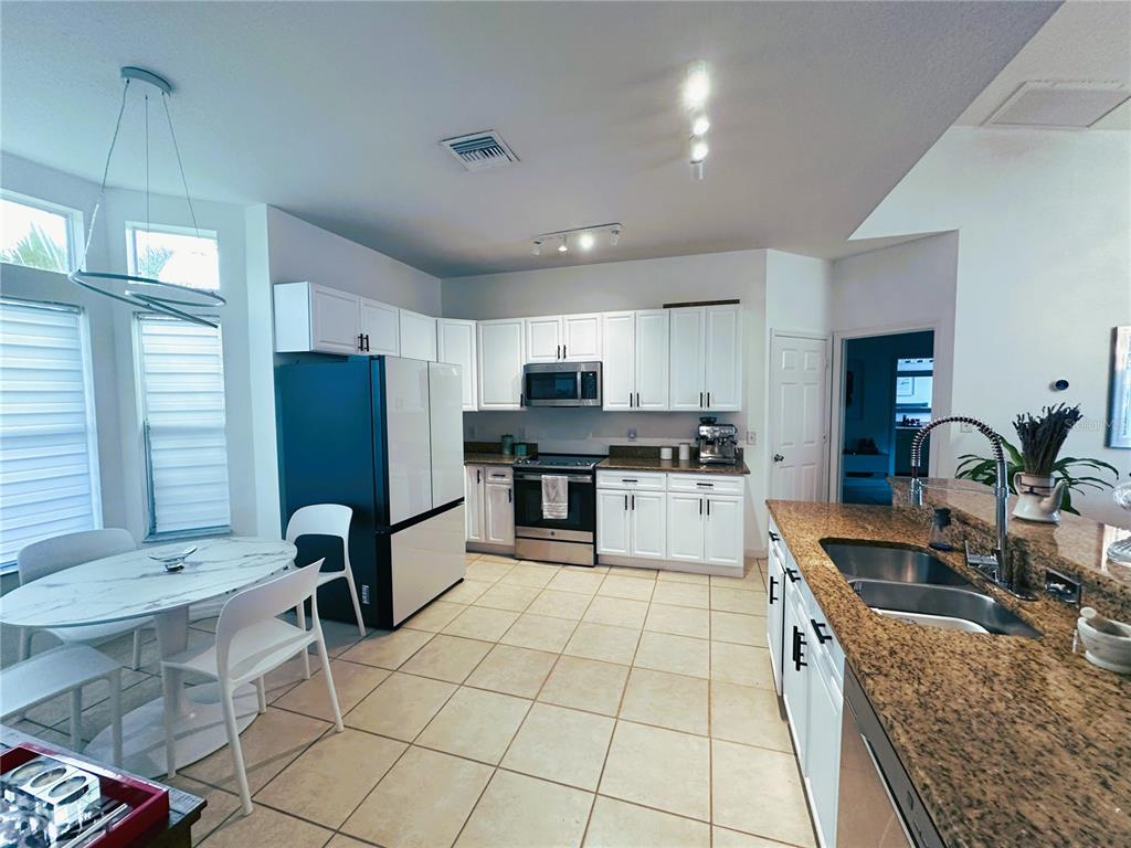 700 Castillo Place St. Cloud, FL 34769 - Photo 9 of 43 a kitchen with granite countertop a sink appliances cabinets and counter space