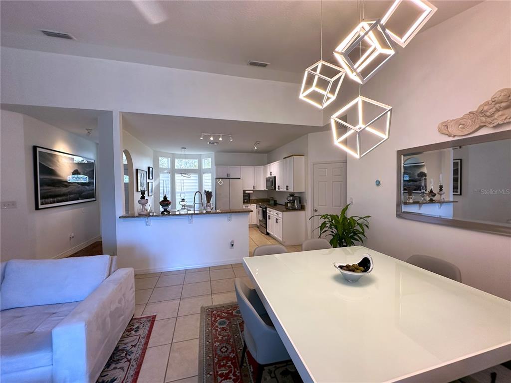 700 Castillo Place St. Cloud, FL 34769 - Photo 10 of 43 a kitchen with stainless steel appliances kitchen island granite countertop a sink a stove and a dining table