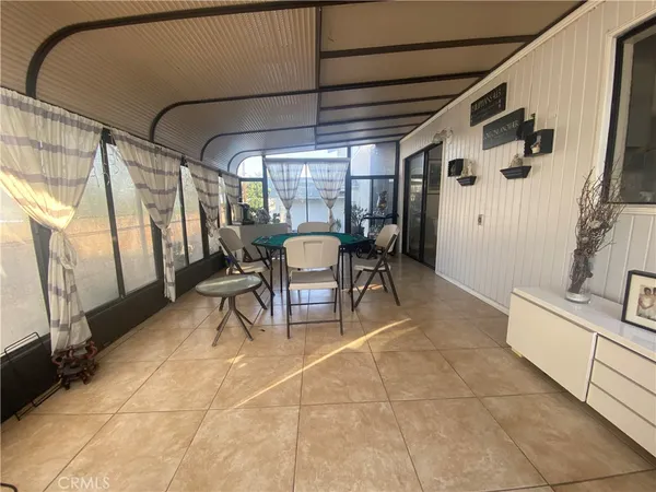 a dining room with furniture and a floor to ceiling window