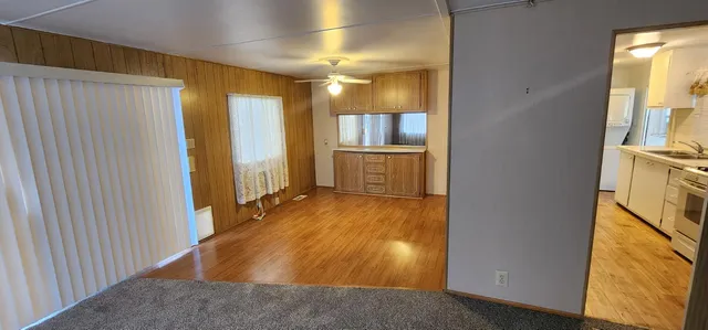 a view of a hallway with wooden floor and furniture