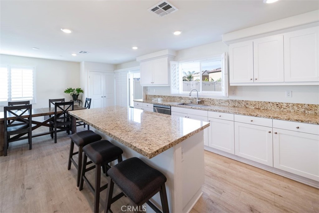 32078 Rambling Court Winchester, CA 92596 - Photo 18 of 48 a kitchen with counter space dining table chairs sink and cabinets
